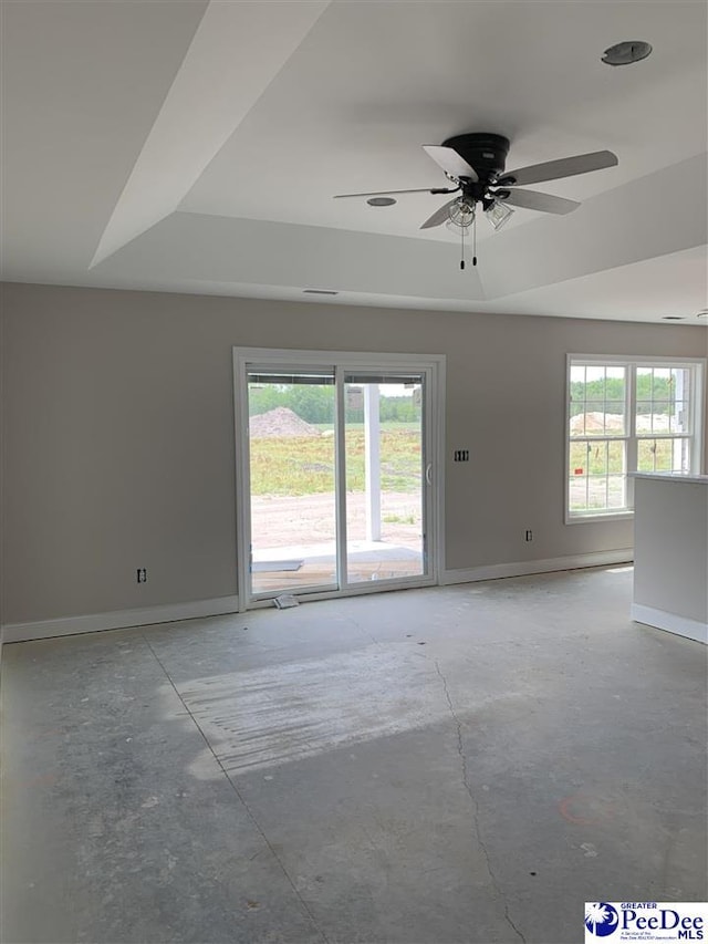 empty room featuring unfinished concrete floors, ceiling fan, and baseboards
