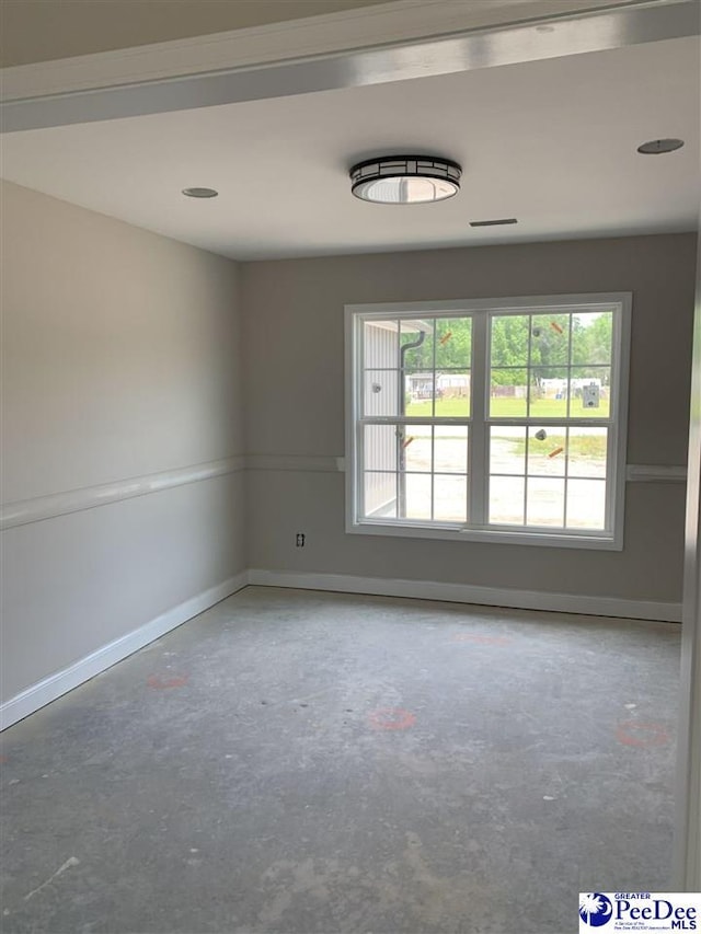 unfurnished room with unfinished concrete floors and baseboards