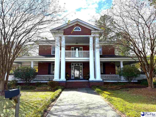 greek revival house with a front yard and a porch