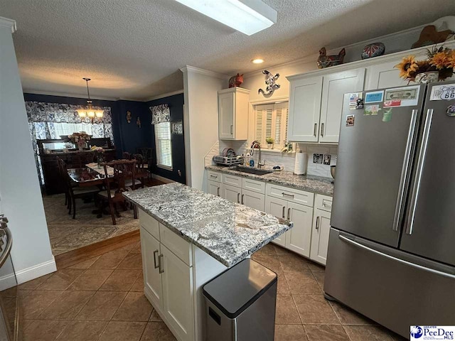 159 Ridge Rd, Cheraw, SC 29512 - kitchen with freestanding refrigerator, ornamental molding, white cabinetry, a chandelier, and dark tile patterned floors