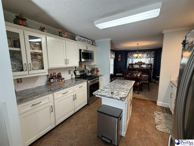 159 Ridge Rd, Cheraw, SC 29512 - kitchen featuring appliances with stainless steel finishes, white cabinetry, tasteful backsplash, glass insert cabinets, and crown molding