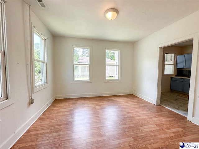 empty room with a healthy amount of sunlight and light wood-type flooring