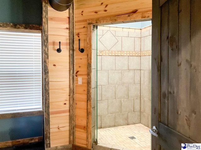 bathroom featuring wooden walls and a tile shower