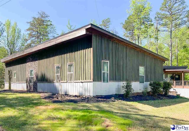 view of home's exterior with board and batten siding and a lawn