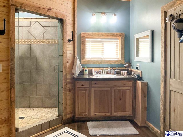 full bathroom with a stall shower, a healthy amount of sunlight, wood finished floors, and vanity