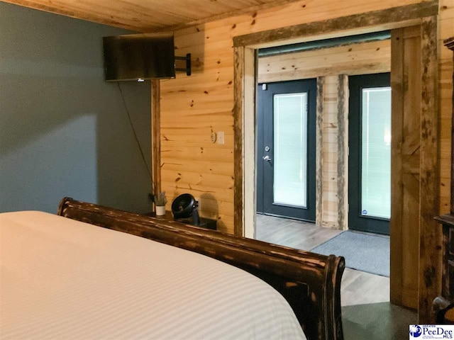 bedroom featuring wood finished floors, wooden walls, and wooden ceiling