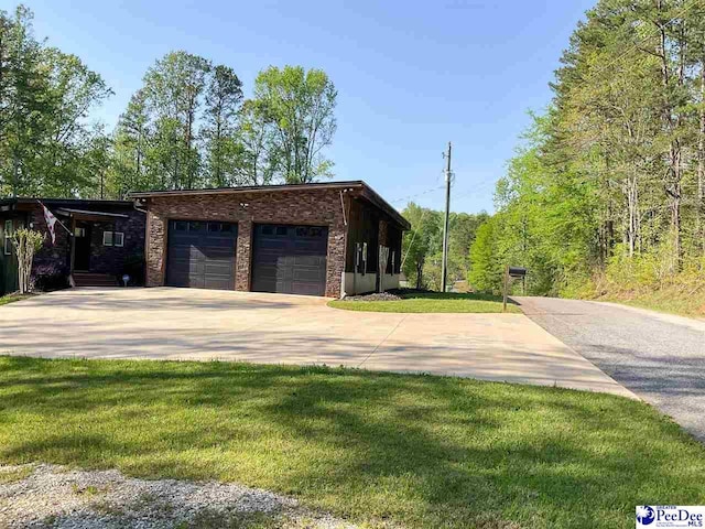 exterior space featuring a lawn, concrete driveway, and an attached garage