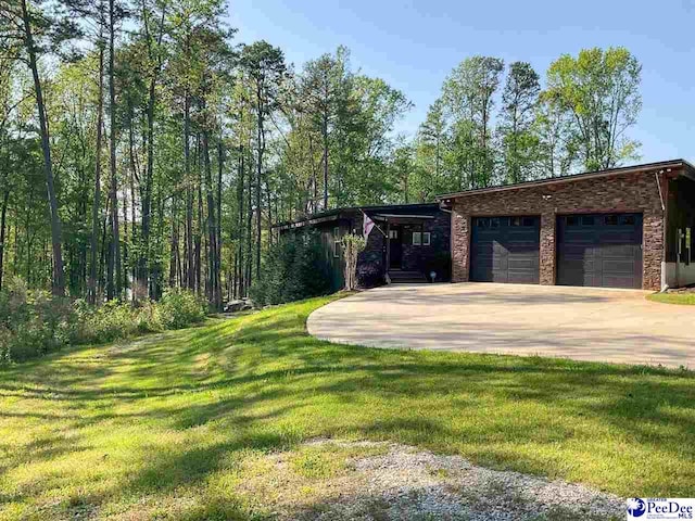 view of front of home featuring a garage, a front lawn, and concrete driveway