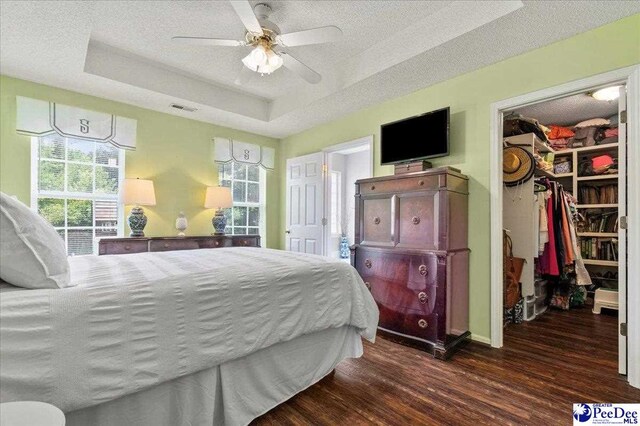 657 Red Tip Cir, Florence, SC 29501 - bedroom with a raised ceiling, a spacious closet, dark wood finished floors, a textured ceiling, and a closet