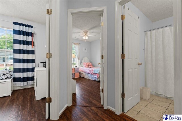 657 Red Tip Cir, Florence, SC 29501 - corridor featuring a textured ceiling, wood finished floors, plenty of natural light, and baseboards