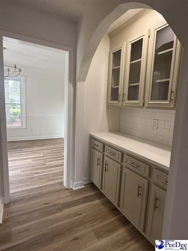 418 S Thomas Rd, Florence, SC 29501 - bar featuring wood finished floors, arched walkways, tasteful backsplash, and baseboards