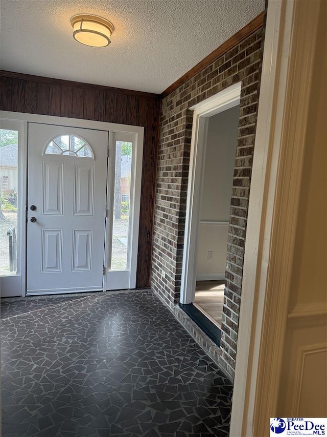 418 S Thomas Rd, Florence, SC 29501 - foyer with brick wall, a textured ceiling, stone finish flooring, crown molding, and wooden walls