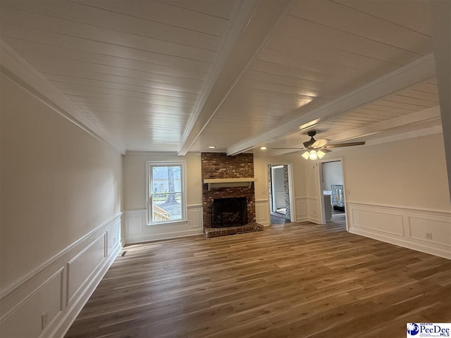 418 S Thomas Rd, Florence, SC 29501 - unfurnished living room featuring a decorative wall, dark wood-type flooring, a brick fireplace, wainscoting, and ceiling fan