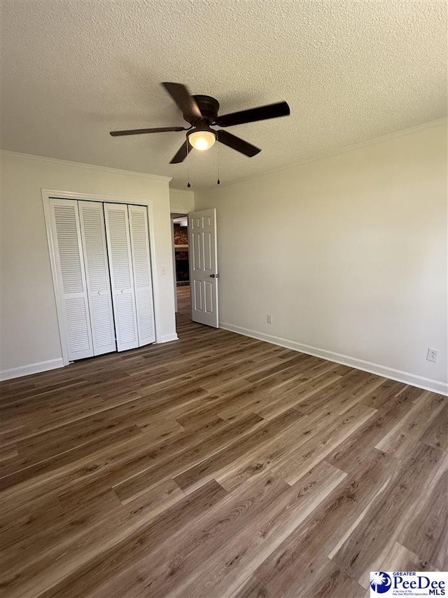 418 S Thomas Rd, Florence, SC 29501 - unfurnished bedroom with a closet, dark wood-type flooring, a textured ceiling, and baseboards