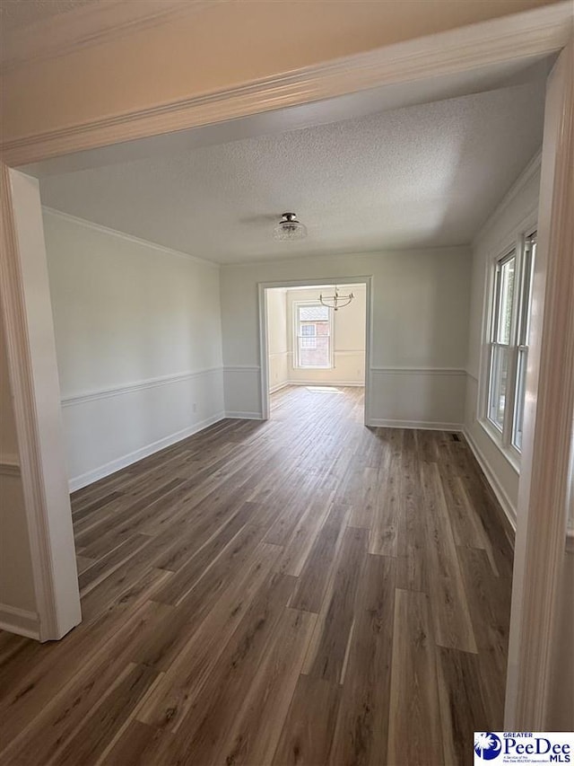 418 S Thomas Rd, Florence, SC 29501 - spare room featuring a chandelier, dark wood-style flooring, healthy amount of natural light, crown molding, and a textured ceiling
