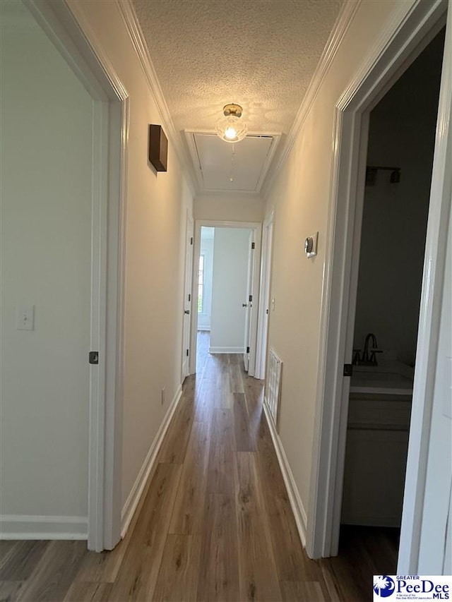 418 S Thomas Rd, Florence, SC 29501 - hallway with attic access, wood finished floors, a textured ceiling, ornamental molding, and baseboards