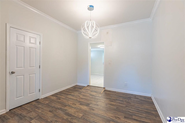 spare room featuring crown molding, wood finished floors, baseboards, and a chandelier