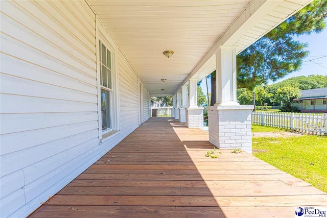 deck featuring covered porch and fence