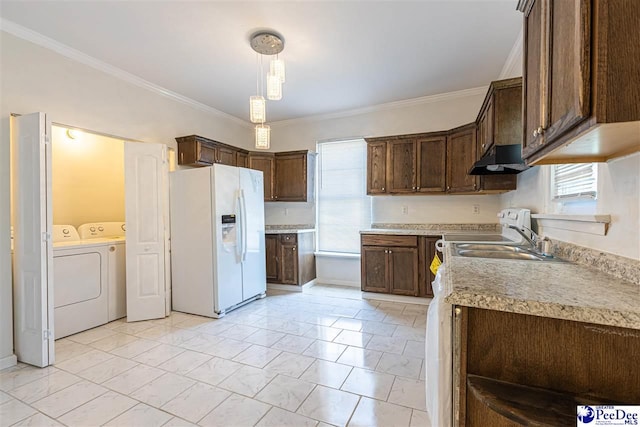 kitchen featuring under cabinet range hood, white refrigerator with ice dispenser, washing machine and clothes dryer, dark brown cabinets, and hanging light fixtures