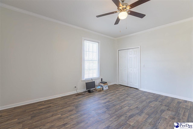 unfurnished bedroom with dark wood-type flooring, a ceiling fan, a closet, crown molding, and baseboards