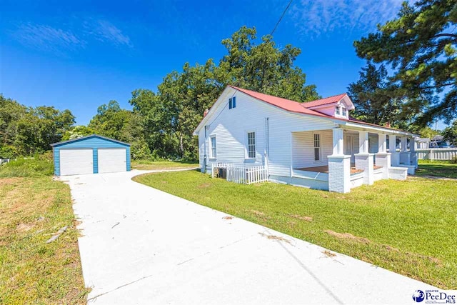 view of side of property featuring a garage, an outbuilding, a porch, and a lawn