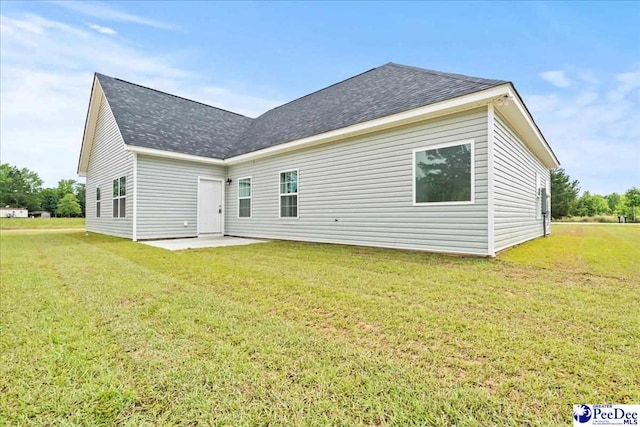 5301 Meadow Prong Rd, Effingham, SC 29541 - rear view of house with roof with shingles, a lawn, and a patio