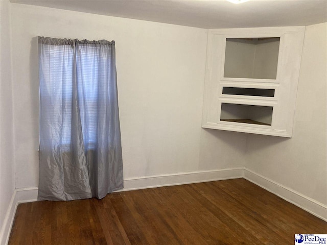 spare room with dark hardwood / wood-style flooring