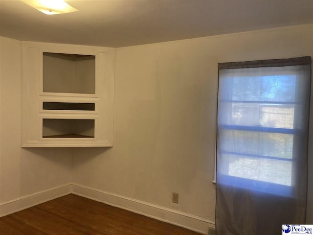 spare room with dark wood-type flooring