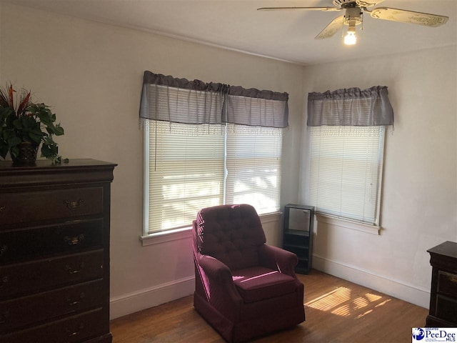 sitting room with hardwood / wood-style flooring and ceiling fan