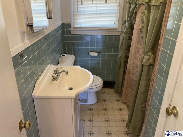 bathroom with tile walls, plenty of natural light, tile patterned floors, and toilet