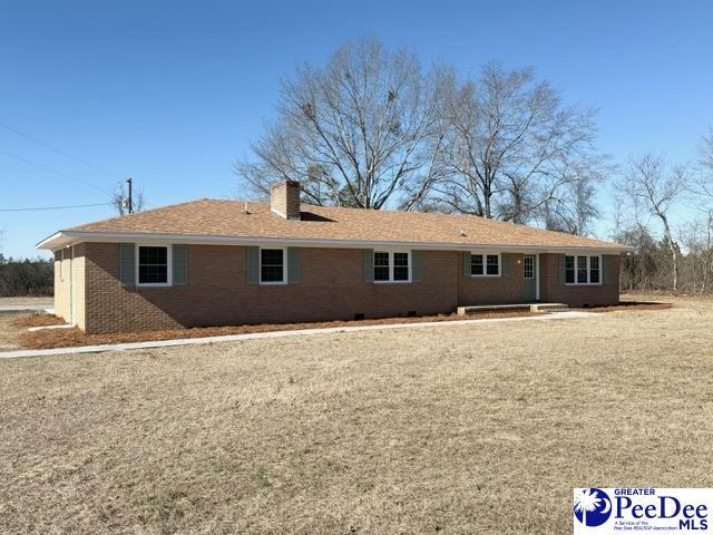 back of house with a chimney and brick siding