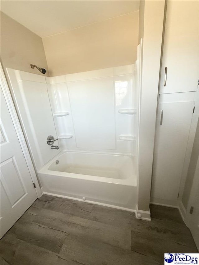 full bath featuring shower / washtub combination and wood finished floors