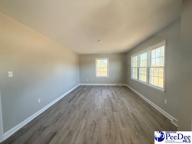 unfurnished room with wood finished floors and baseboards