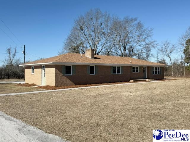 rear view of property featuring brick siding and a chimney