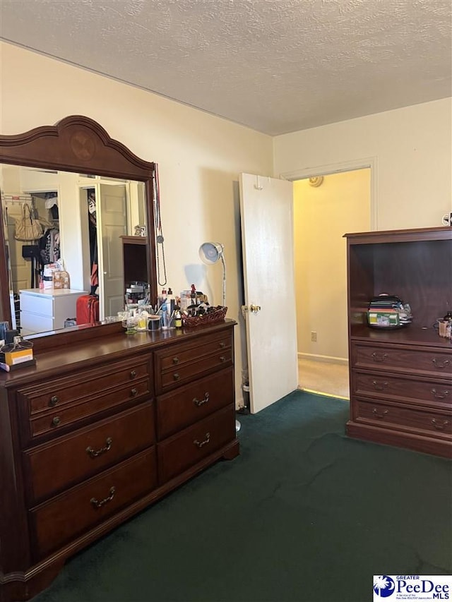 bedroom with dark carpet and a textured ceiling