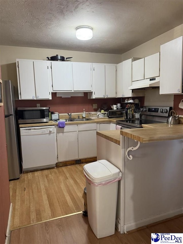 kitchen featuring white cabinetry, appliances with stainless steel finishes, and light hardwood / wood-style flooring