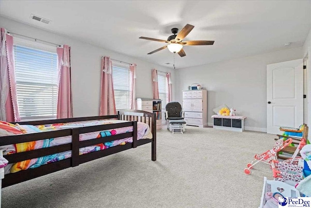 carpeted bedroom featuring ceiling fan and multiple windows