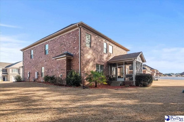 view of side of property featuring a yard and a sunroom