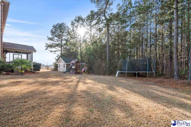 view of yard with a trampoline and a storage shed