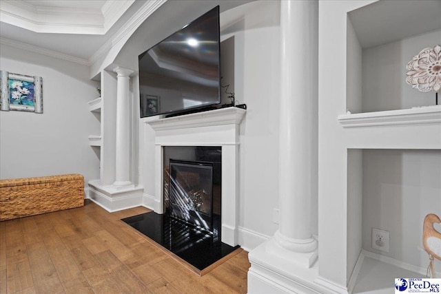 living room featuring ornate columns, crown molding, and hardwood / wood-style flooring