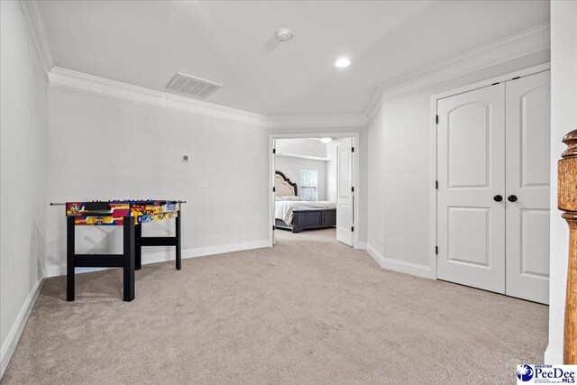 recreation room featuring ornamental molding and light colored carpet