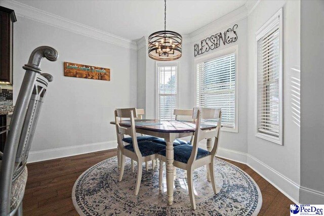 dining area featuring crown molding, dark hardwood / wood-style floors, and an inviting chandelier