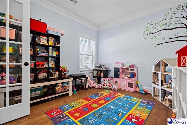 recreation room featuring hardwood / wood-style floors and ornamental molding