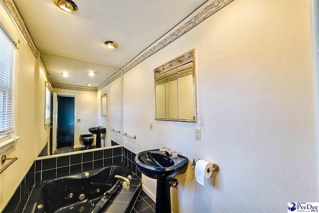 bathroom with ornamental molding, sink, tile patterned floors, and a tub to relax in