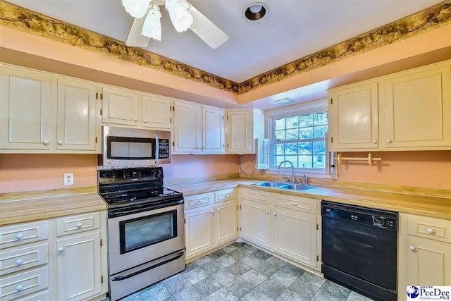 kitchen with stainless steel appliances, white cabinetry, sink, and ceiling fan