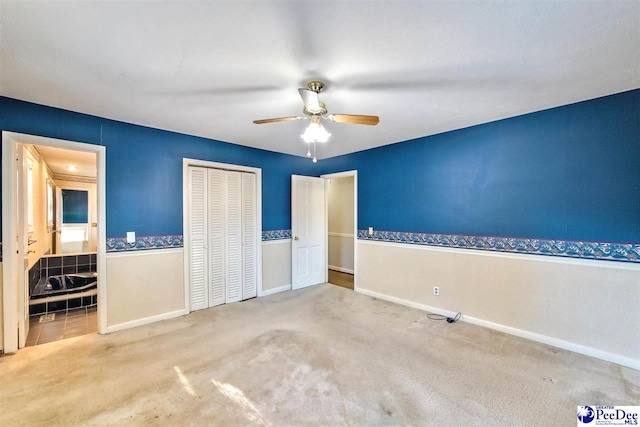 unfurnished bedroom with ceiling fan, carpet flooring, and a closet