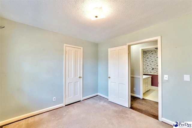 unfurnished bedroom featuring light carpet and a textured ceiling