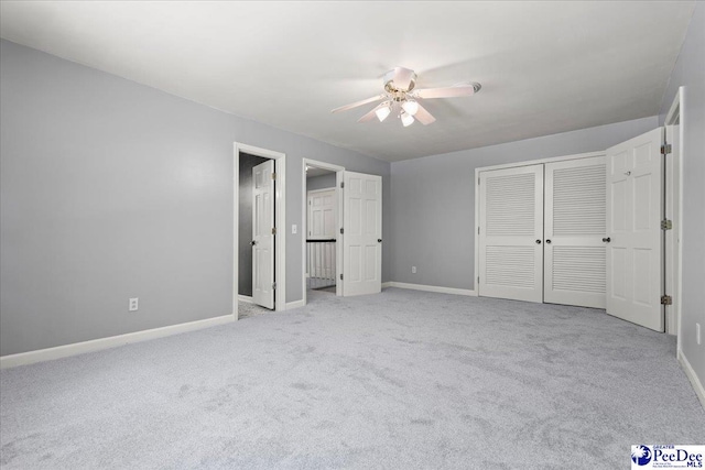 unfurnished bedroom with a closet, baseboards, a ceiling fan, and carpet floors