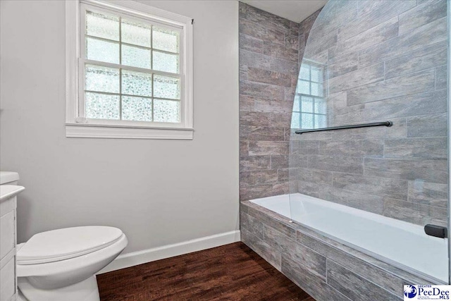 full bath with baseboards, a healthy amount of sunlight, toilet, and wood finished floors