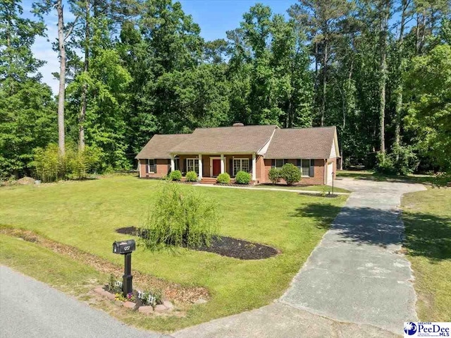 single story home featuring a porch, a front lawn, and driveway